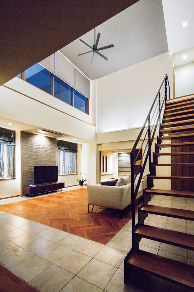 -delphi- デルフィ（藤井建築事務所） 【デザイン住宅、建築家、鉄骨鉄筋コンクリート構造】吹き抜けの大空間をより広く見せるのは、スタイリッシュなスケルトン階段。タイルとアメリカンチェリー材のヘリンボーンの床の組み合わせはご主人の提案で。無垢材の部分には床暖房を設置