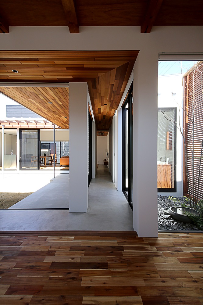 インフィルプラス【浜松市中央区志都呂町2-41-3・モデルハウス】子ども部屋から見たモルタルの廊下。中庭を廊下で囲むことで、縁側が各室をつなげているような印象に。天井はレッドシダー張り