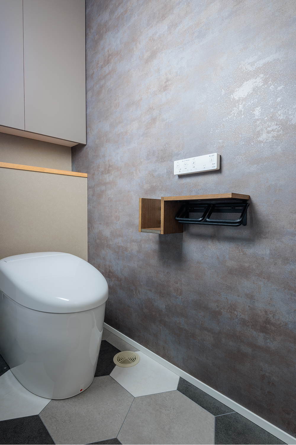 tact design firm【デザイン住宅、子育て、間取り】シンプルでモダンなトイレ。アクセントウォールとオシャレな床タイルが特徴的で、落ち着いた空間を演出している