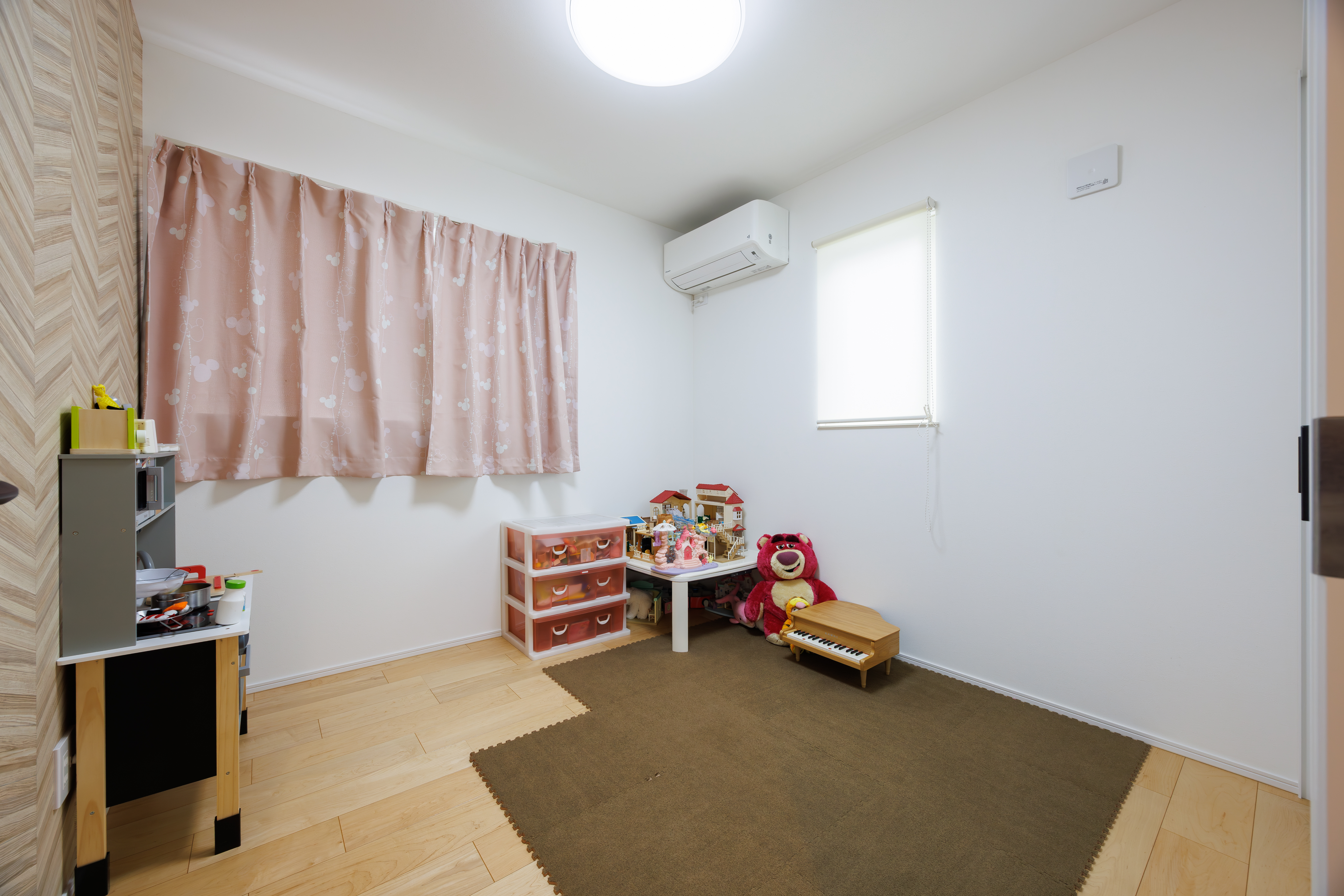 アーキホームライフ｜明るい子ども部屋はナチュラルな木目の床とシンプルな白壁が特徴的。十分なスペースで、子どもが自由に遊べる環境が整っている。