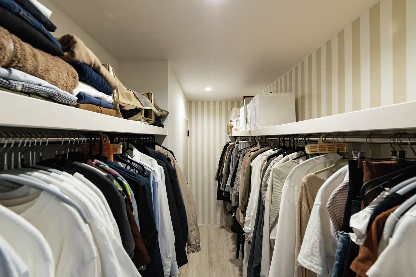 HAPPY HOUSE（山田工務店）【デザイン住宅、子育て、間取り】ウォークインは当初よりも幅を狭くし、廊下側の収納にスペースを充てた。クロスはストライプを選択。左手奥にご主人の書斎が用意されている