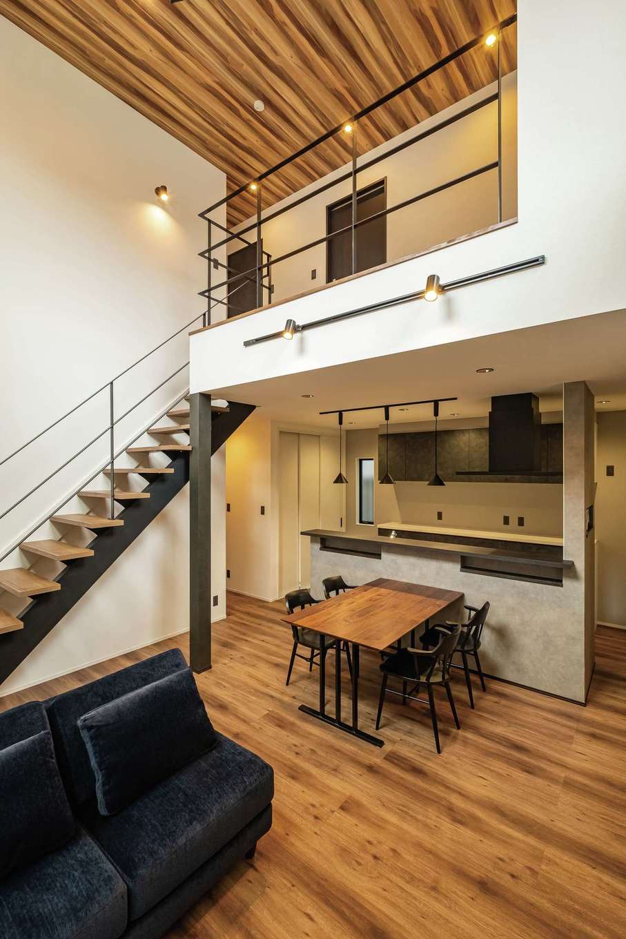 TOZAKI HOME 戸﨑建設　【デザイン住宅、間取り、インテリア】限られた面積で空間を最大限に使って広く見せる吹き抜けリビング。2階部分の2面に大きな窓があり、リビングに光が降り注ぐ。デザイン性の高いスチール手すりのストリップ階段は光を通し、開放感がより高まる