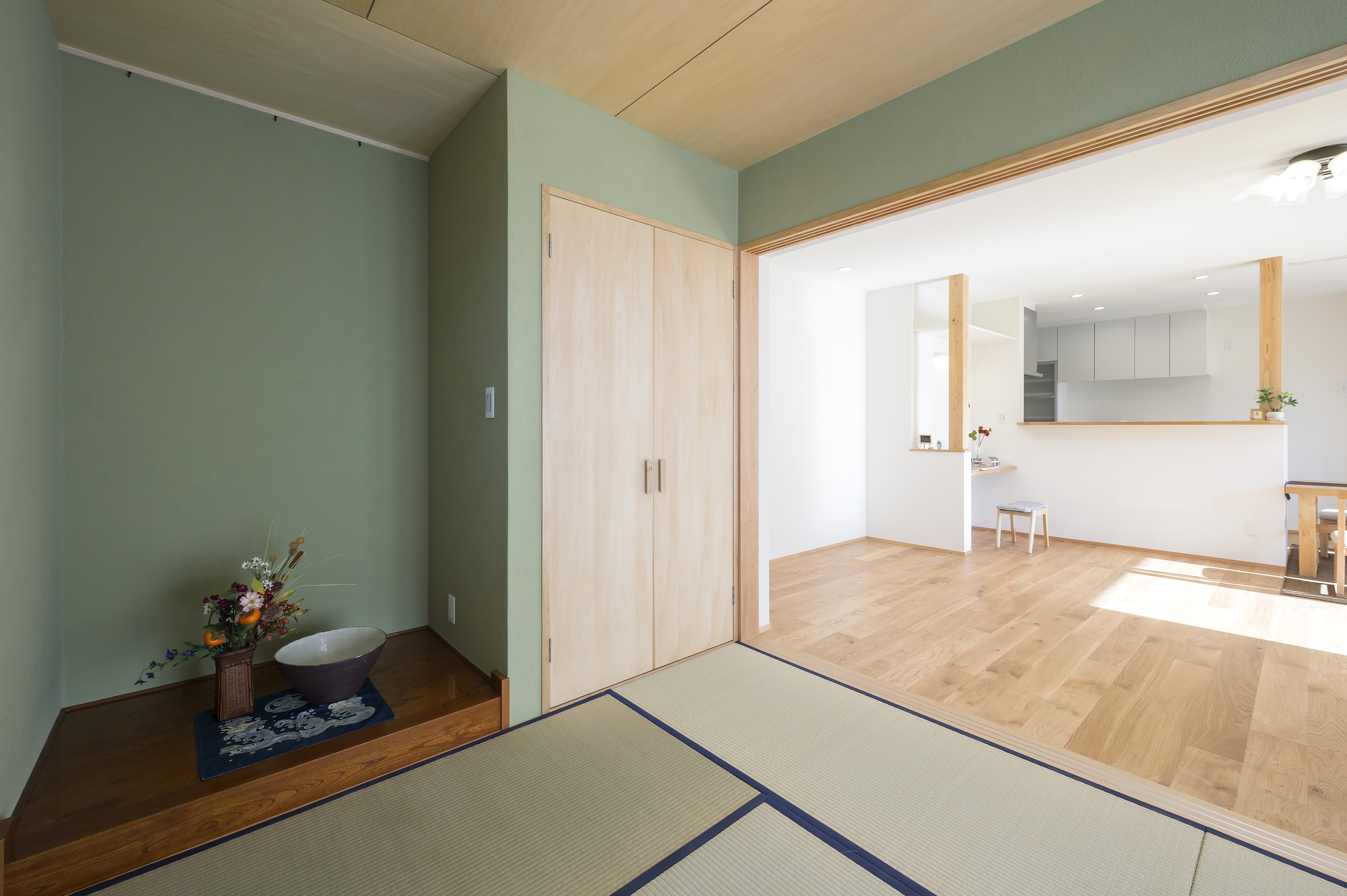 しあわせの住まい一級建築士事務所｜畳の落ち着いた雰囲気が広がる和室。白い壁と木製の引き戸が、シンプルかつ上品な空間を演出している。