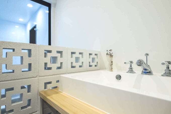 沖縄の建築物に用いられる「花ブロック」を洗面脱衣所の仕切り壁に。カッティングデザインはかわいいだけでなく、通気性もあるので、水回りにはぴったり