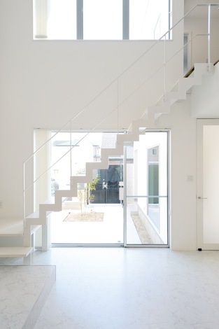 純白のリビング階段が空間のアクセントに。鉄骨をベースに、踏み板には木を使用した。形状からイナズマ階段とも言う、蹴込み板がなく、骨組みだけのスタイリッシュなシルエット。リビングからはもちろん、中庭やガレージ、玄関ホールからも見えるように、あえて窓際にレイアウト。ソファに寝転がって、階段越しに見る空の景色がお気に入りなのだそう