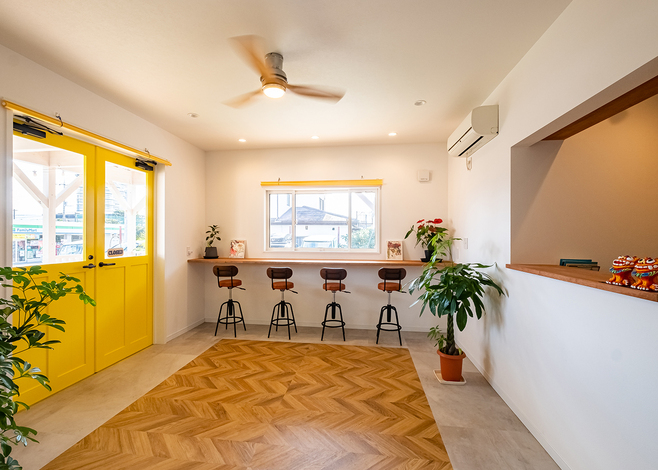 黄色いドアが明るい印象を一層引き立てる