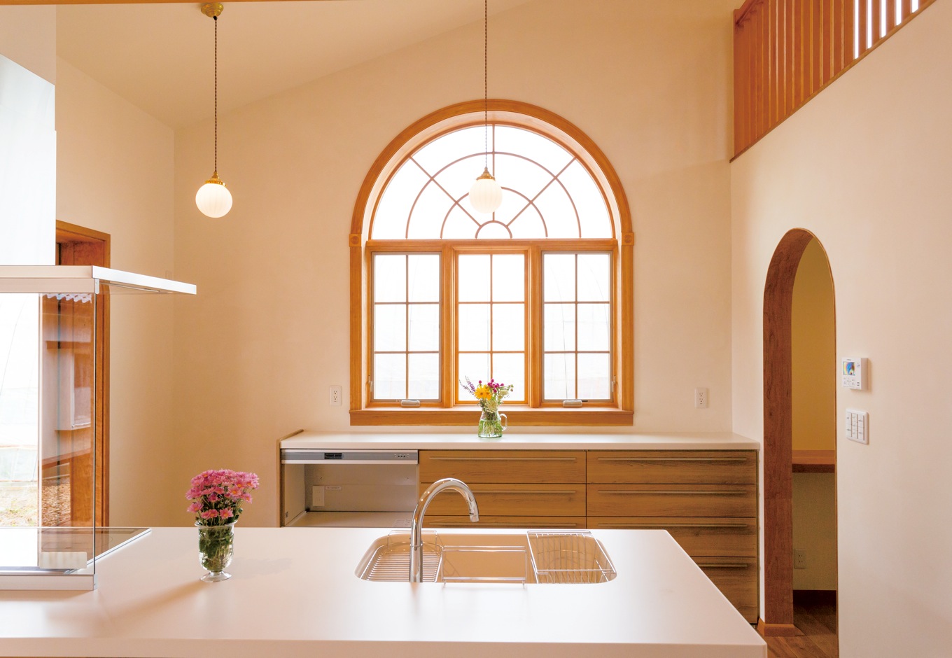 片桐建設【デザイン住宅、子育て、輸入住宅】奥さま一番のこだわりは、キッチン奥のアーチの木窓。経年変化が楽しみなチェリー材を使い、『片桐建設』が造作した。映画に登場するような外国の家を思わせる