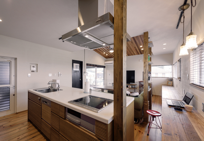 キッチンは「アール・プラス・ハウス」のオリジナル。対面式で室内全体が見渡せる。隣のカウンターには工事用の足場板を使用。ヴィンテージ感漂う室内にぴったりマッチしている。左側のドアは生ゴミなどを出しておけるサービスバルコニーへと続く