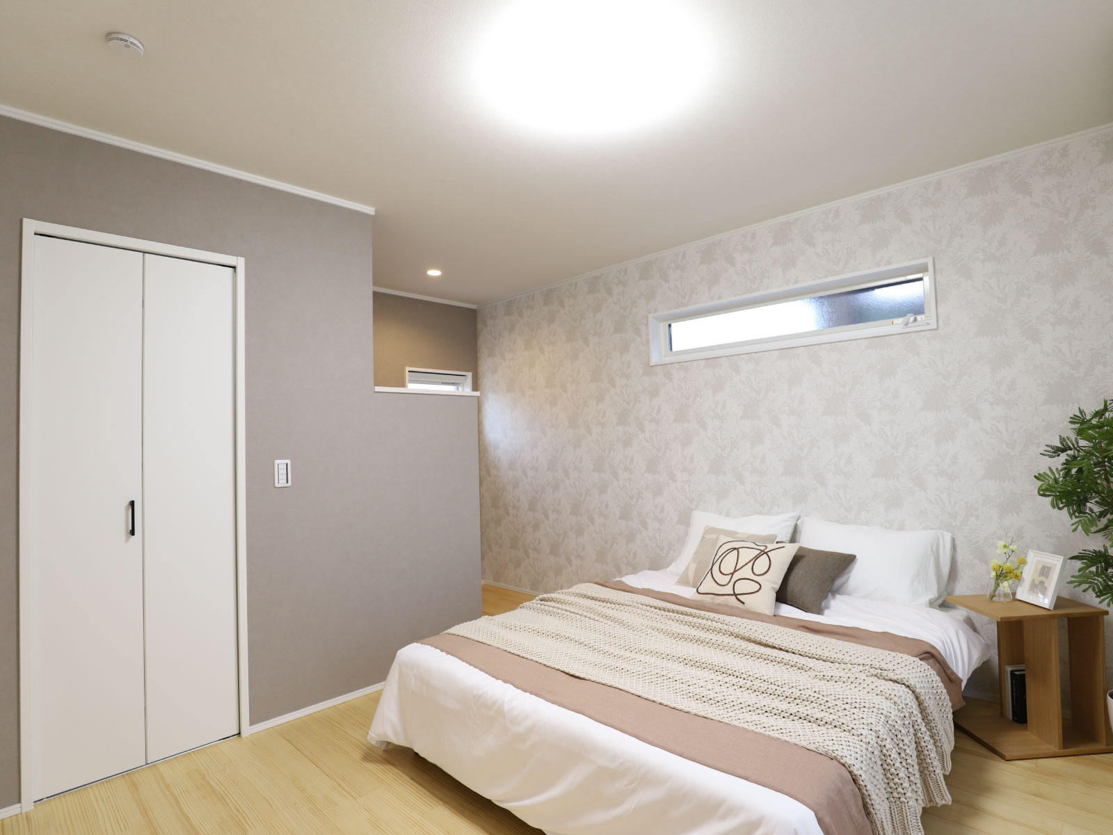 ヘスタホーム｜落ち着きのあるシンプルでモダンな寝室。ベッドサイドには小物を置くことができるスペースがある。快適な睡眠環境を提供する空間。