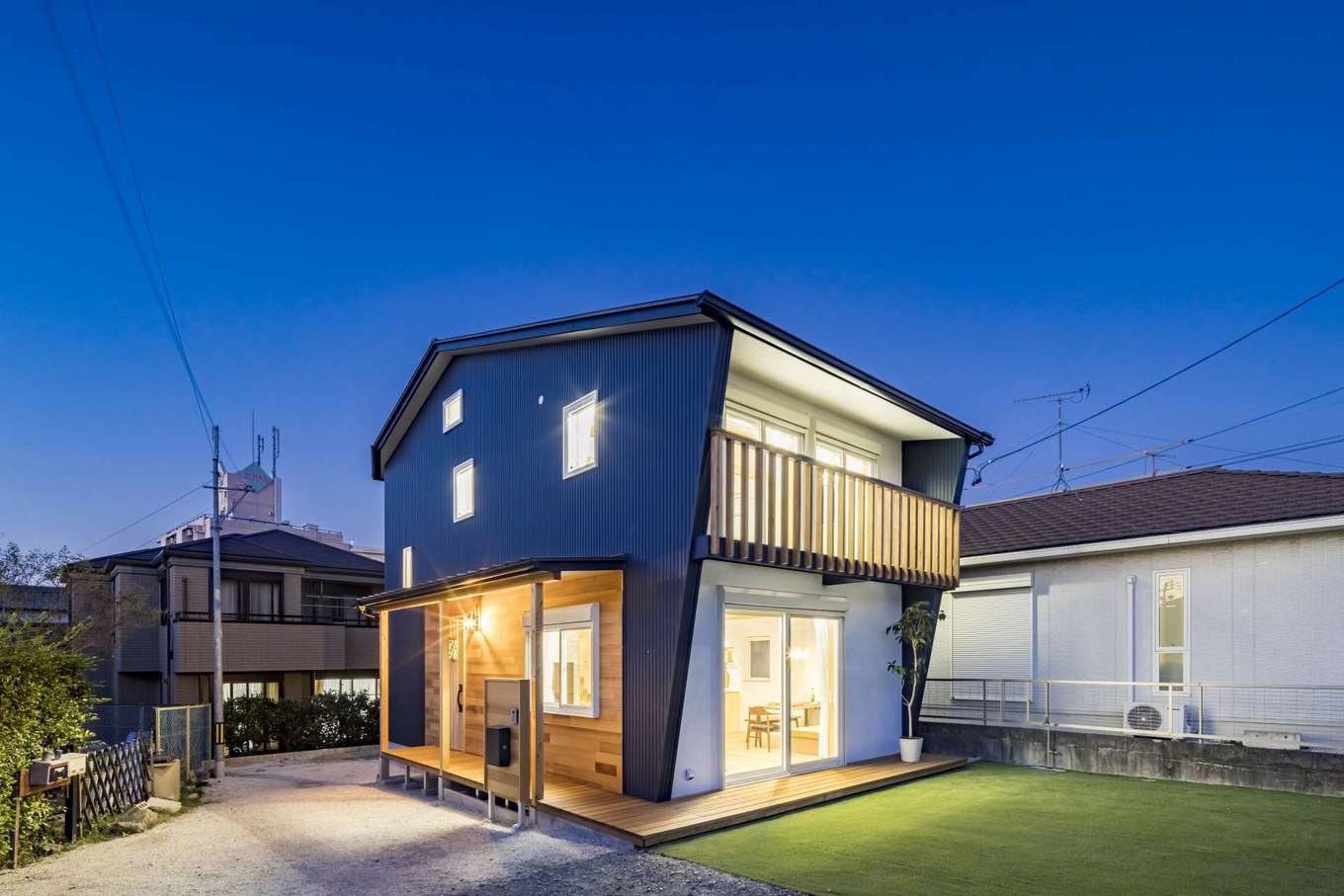 umeken/梅村建築【デザイン住宅、子育て、省エネ】ブルーのガルバリウム鋼板とカルクウォール（スイス漆喰）がバランスよく調和した総2階の外観。L字型のウッドデッキがスロープ状になって玄関までつながる