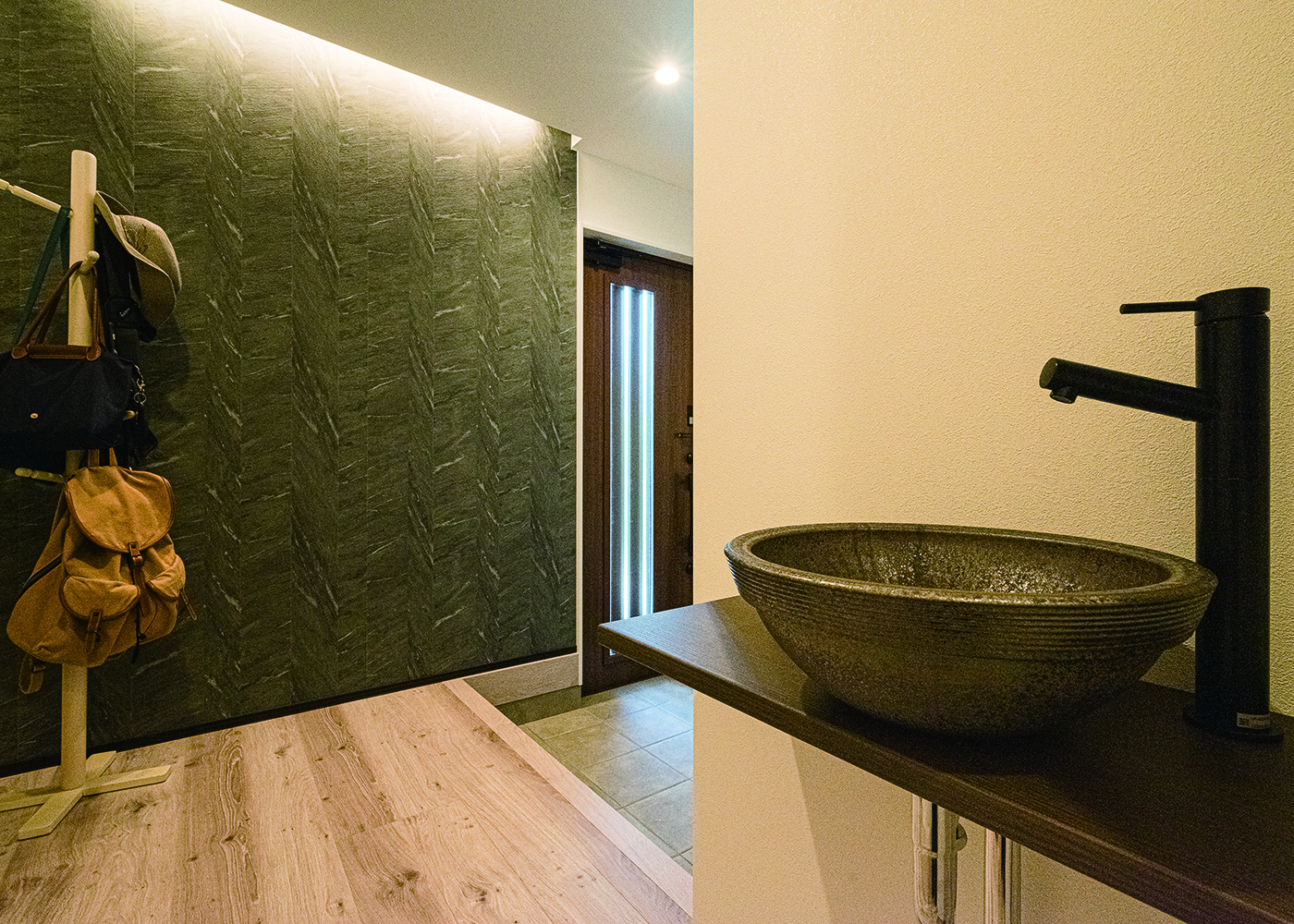 HAPPY HOUSE（山田工務店）【子育て、間取り、屋上バルコニー】間接照明のやわらかな光が帰宅を迎える。すぐ手を洗えるよう近くに洗面を設けた。右手のシューズクロークは広さが感じられるようあえてオープンにし、ロールスクリーンで区切るスタイルに