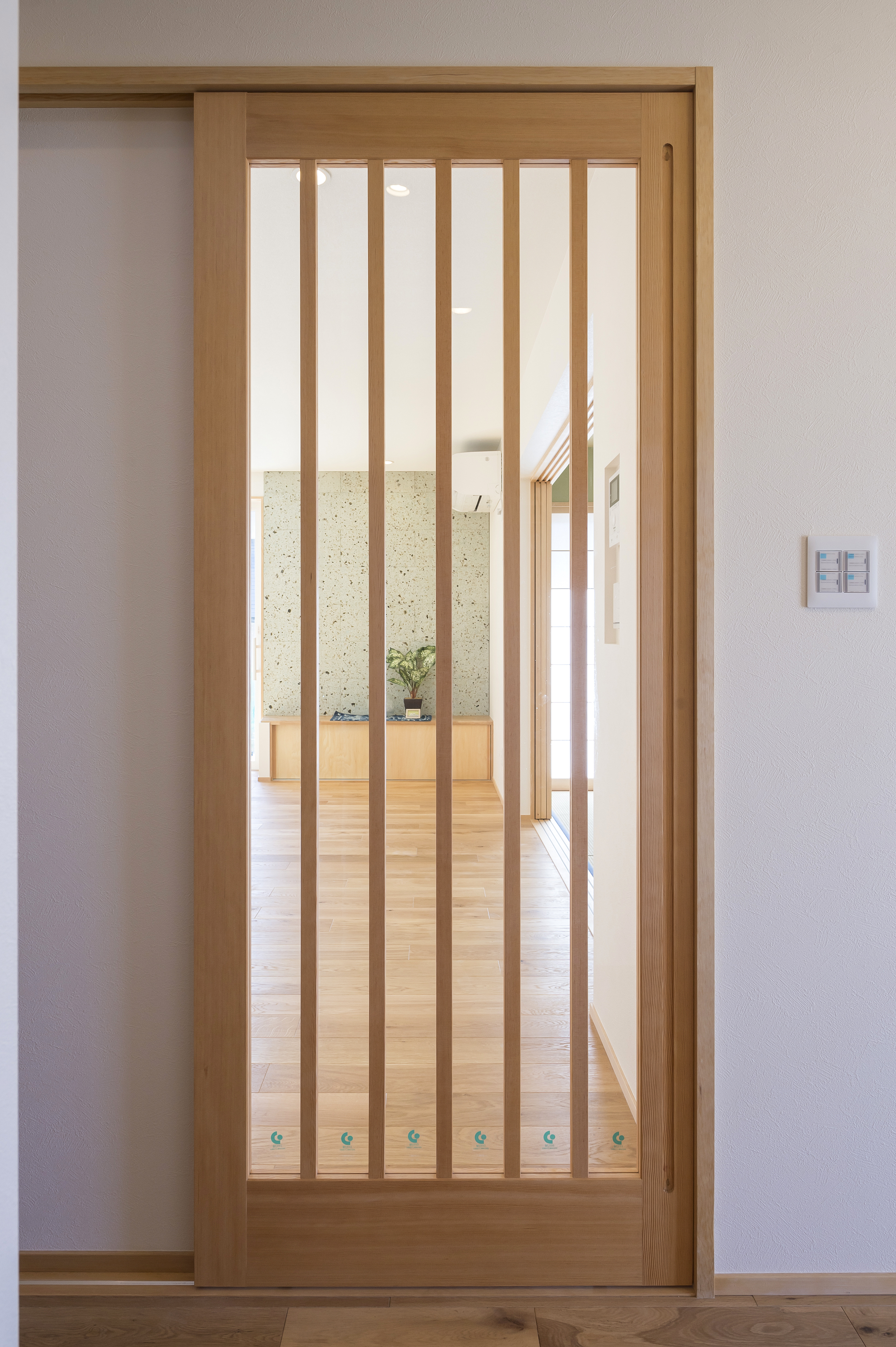 しあわせの住まい一級建築士事務所｜シンプルで上品な木製の引き戸が特徴的な玄関ホール。明るい木目が空間に落ち着きを与え、温かみのある雰囲気を演出する。