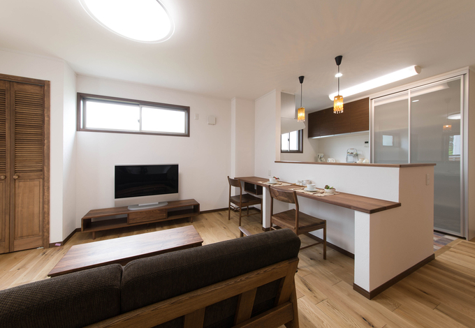 ご両親のLDK。あえて部屋の広さを削って設けた左手のデッキから、たっぷりの光と風  がもたらされ、長年の不満が解消された。床には味わい豊かなアンティークオークを選択