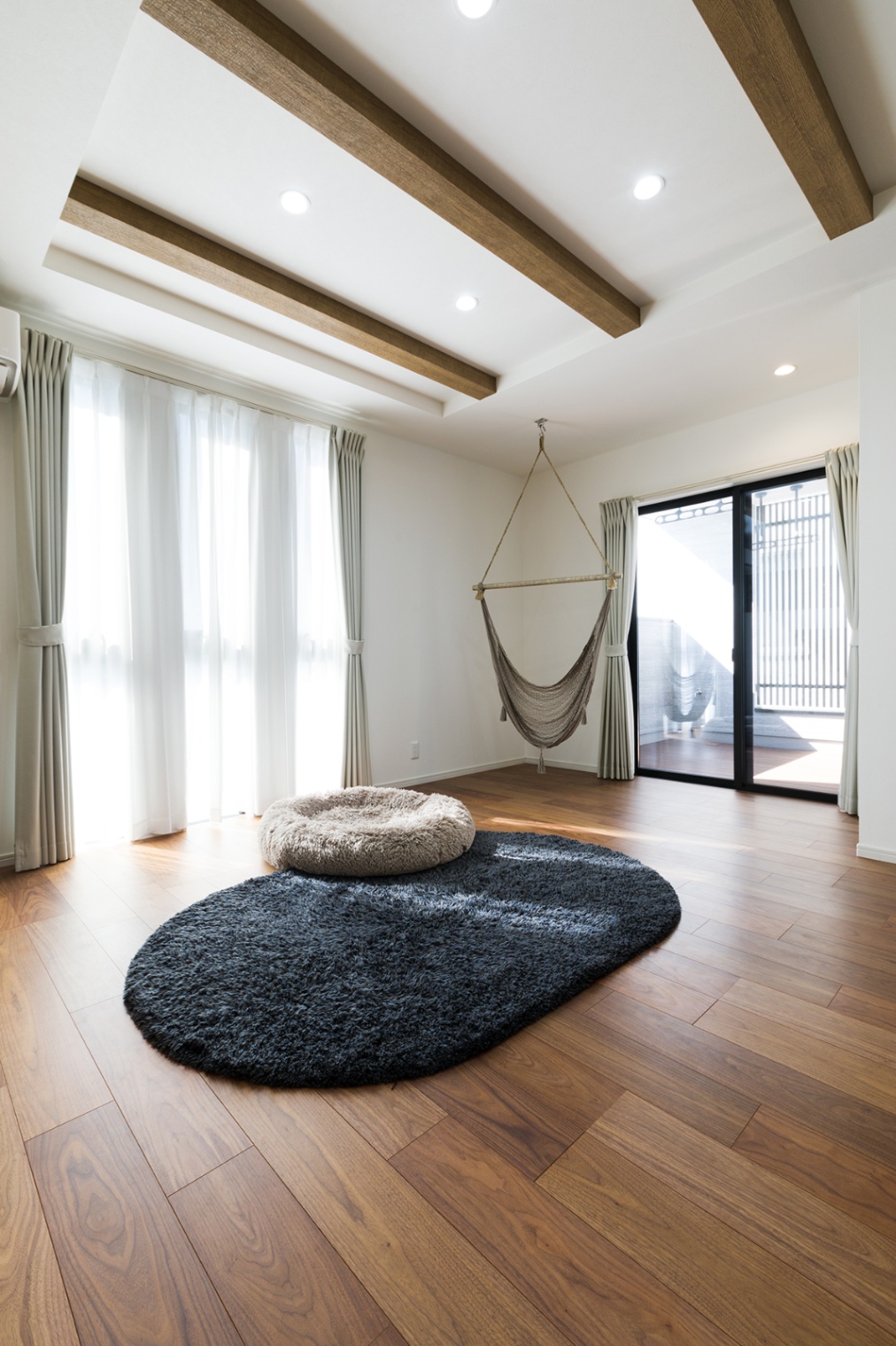 ナイスホーム｜ハンモックは最初から絶対欲しかったアイテムだそう。家族みんなのリラクゼーションスペースとして活躍している。ソファを置いていない広々リビングは、愛犬にとっていい遊び場になっている