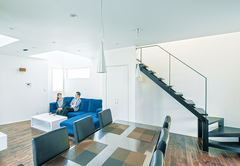 陰影が美しい白とダークブラウンの空間を黒い鉄骨階段が引き締める。木とアイアンの組み合わせが重厚感のあるダイニングテーブル「GEN」、ソフトな座り心地の椅子は「SIGUERRO」。ハコを造って終わりではなく家具までトータルにコーディネートするため、どちらも『納得』が開発したインテリア