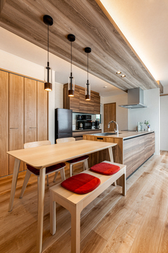 ナチュラルウッドを基調としたLDK。天井と床の木目が調和し、暖かみのある落ち着いた空間を演出している。シンプルながらも機能的なデザイン。