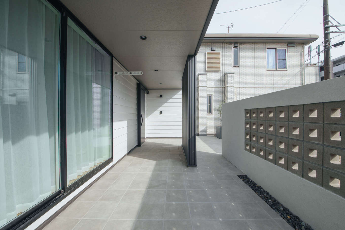 DAITOKU（大得工務店）【デザイン住宅、子育て、間取り】視線を遮りつつ、光と風を取り込むブロック塀。耐久性に優れているタイルデッキは火を使うBBQにも最適だ