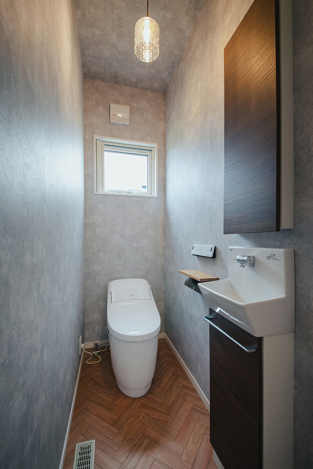 トイレはタンクレストイレと手洗い付きの収納棚を採用