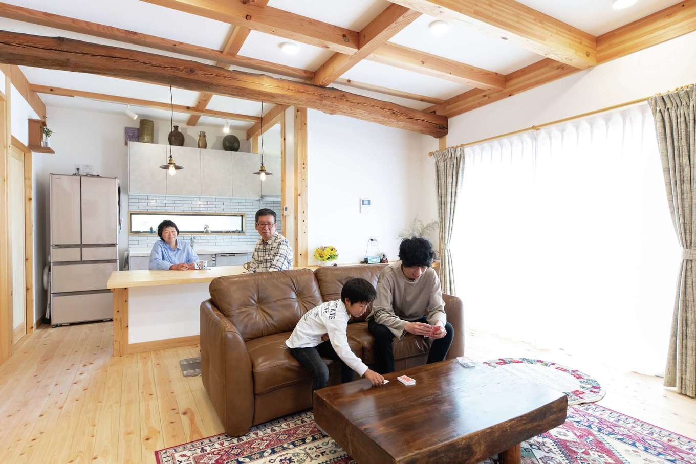 ぽっくハウス静岡（東海ハウス）｜床はヒノキ、壁は漆喰塗り。柱を出した真壁仕様とし、梁を現しにして建具も造作。ナチュラルな素材感が居心地の良さを感じさせる。カウンター上の丸梁のほか、仏間の落とし掛けと床板も旧家の部材を使っている