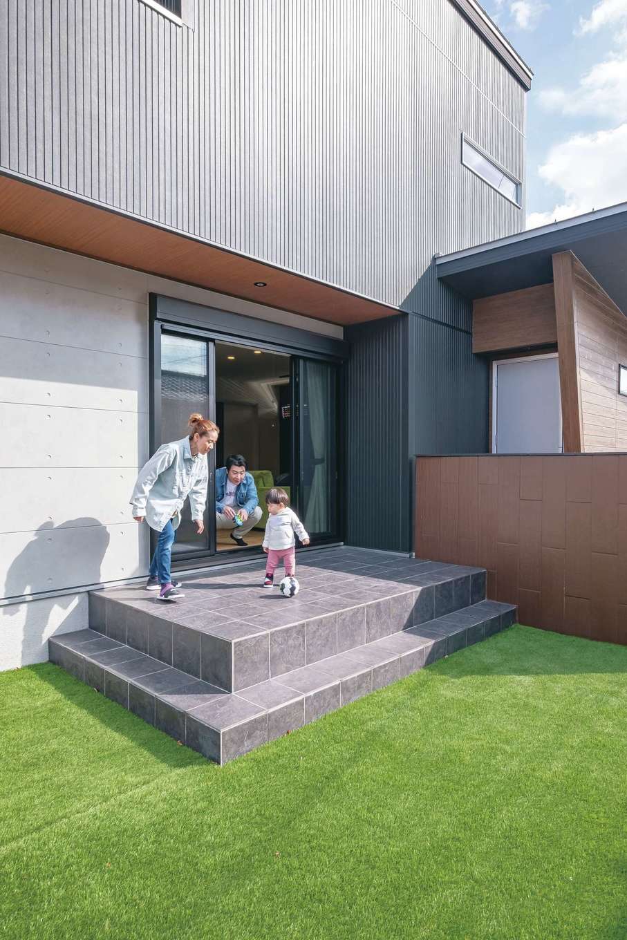 静鉄ホームズ【インテリア、デザイン住宅、子育て】外と室内をゆるやかにつなぐテラスデッキは、リビングの延長として、さまざまな使い方ができる。外からの視線を気にすることなく、家族や友人とBBQや子どもプールなどを楽しめるよう、建物の配置を考慮した。庭もかなり広いため、Yくんがもう少し大きくなったら、パパとキャッチボールやサッカーの練習ができそう