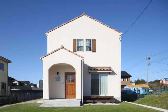 塗り壁とテラコッタ瓦を組み合わせた南欧風の可愛らしい外観。玄関ポーチは雑貨好きの奥様のディスプレイコーナー