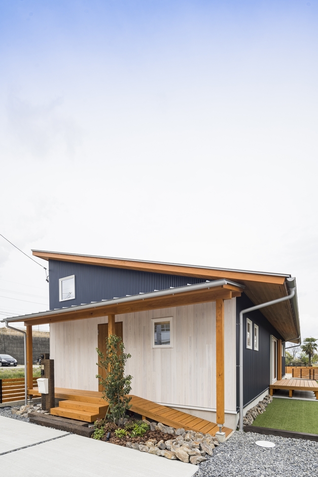片流れの屋根が印象的なスタイリッシュな外観デザイン。ダークブルーのガルバリウムの外壁に天然木の軒天がアクセントに。10kWの太陽光発電を搭載し、ランニングコストを抑えた低燃費な暮らしを実現する