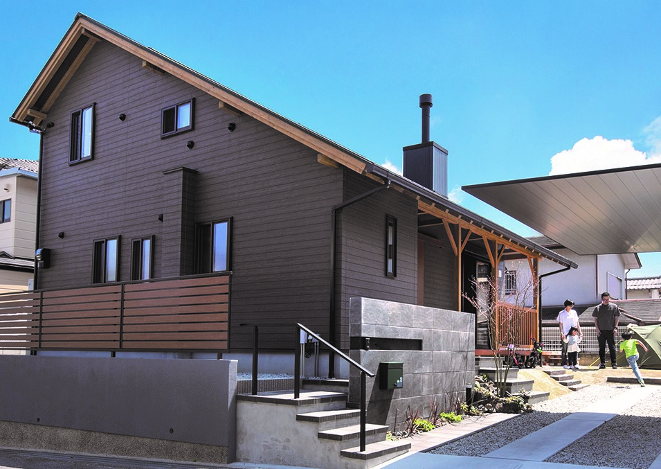 サイエンスホーム【趣味、自然素材、間取り】大胆な片流れの大屋根が印象的な外観。木目調のサイディングやカヴァードポーチを採用することで、薪ストーブやキャンプを楽しむ家族にふさわしいリゾート感を出した