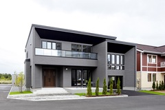 シンプルでモダンなデザインの二階建て住宅の外観。グレーを基調とした外壁が現代的な印象を与え、周囲の環境に自然と溶け込んでいる。