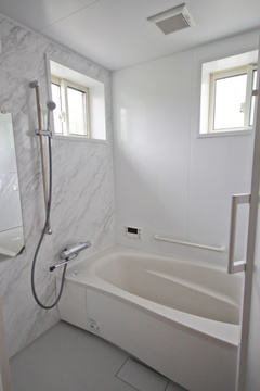 コンパクトながら機能的なバスルーム。光を取り入れる窓があり、明るく清潔な雰囲気を持つ。白を基調としたデザインが清涼感を演出している。