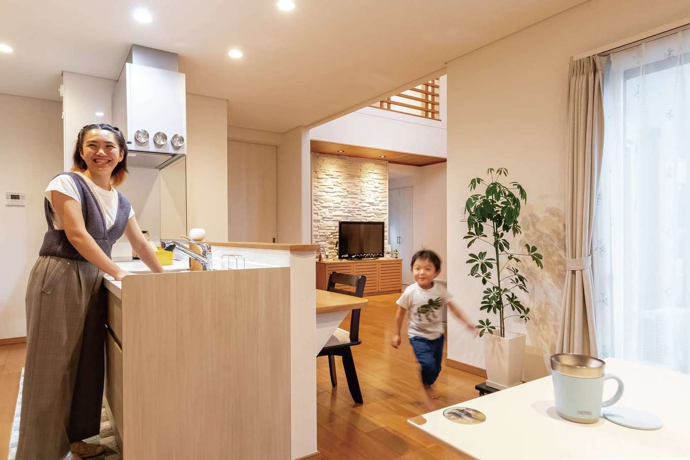 住宅工房 アリアンス【デザイン住宅、省エネ、間取り】家族がどこにいても気配を感じられる位置にキッチンを配置したことで、会話が生まれやすい。水回りへの動線もしなやかで、家事時間を短縮できる