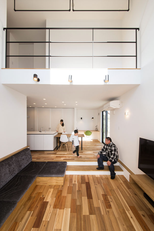 S.CONNECT（エスコネクト）【収納力、趣味、建築家】フロアを一段下げてダイニングとのゾーニングを図ったリビングピット。吹抜けとの相乗効果で縦の空間がいっそう広がり、開放感に満たされる。「リビングピットの段差はちょっと腰かけたりするのに便利で気に入っています」とご主人