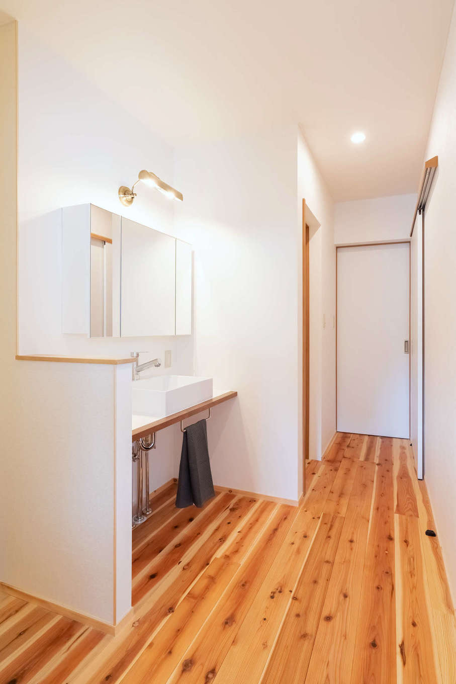ALAIN（アラン）｜２階に設けた造作の洗面コーナー。階段からプライベートルームへ向かう動線上に設けてあり、アクセスが便利。鏡の背面に収納を確保し、コンパクトでありながら機能的に設計されている