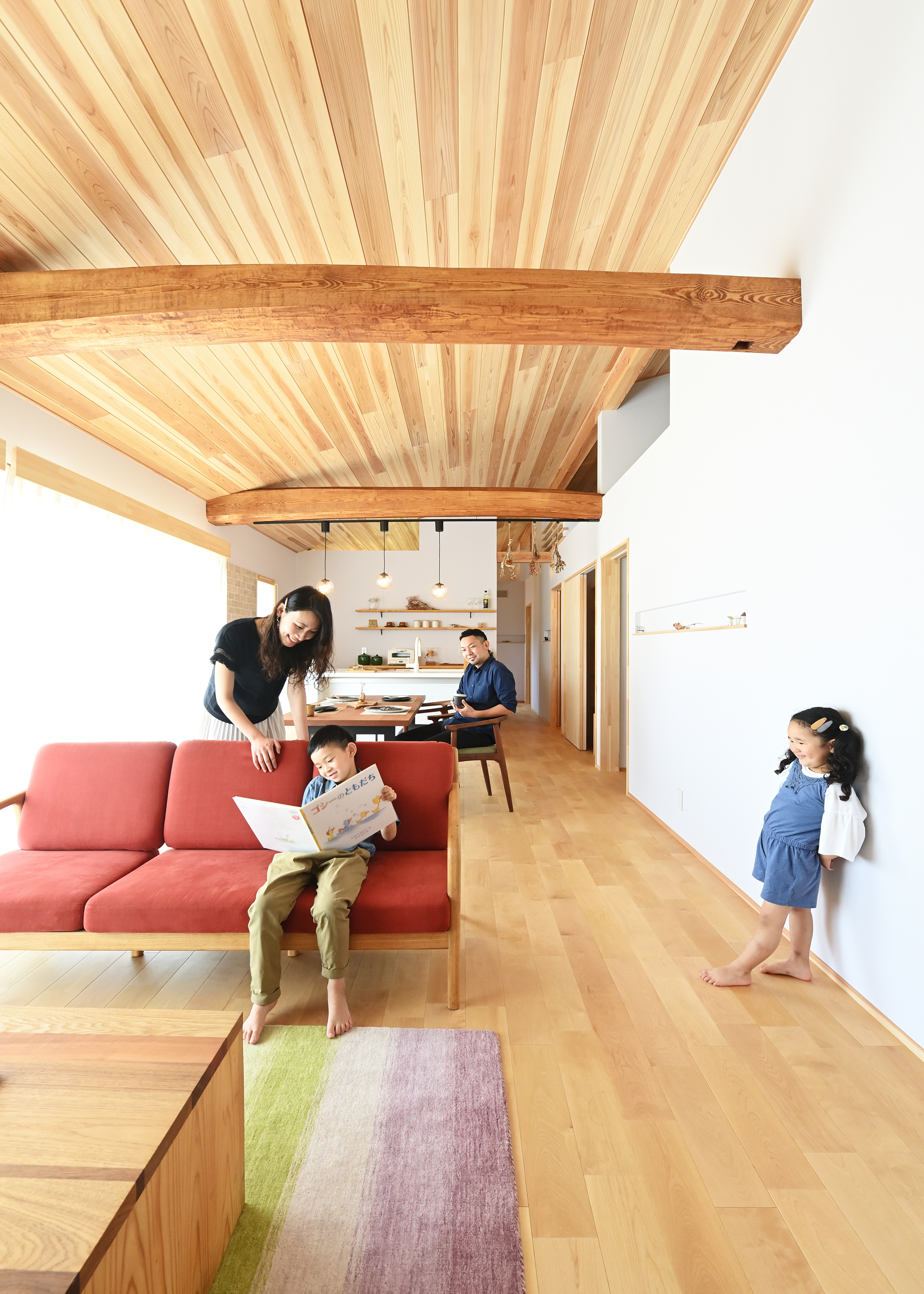 KANAZAWA STYLE/金澤建築【省エネ、間取り、平屋】大きな開口部からたっぷりの光が差し込むLDKは19畳。勾配天井に杉板を、フローリングにカバザクラを採用した空間は、きれいな空気がゆったりと流れ、思わず深呼吸したくなる。2本の太い丸太梁を家族みんなで塗装し、家づくりの思い出に