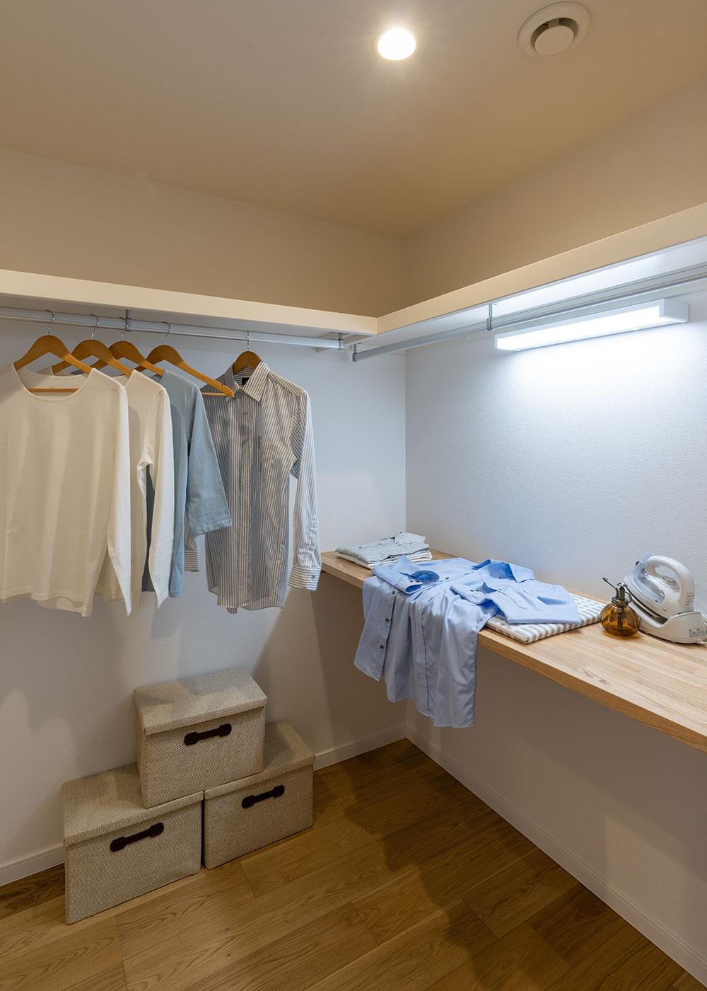 寺田工務店【収納力、狭小住宅、省エネ】大容量のウォークインクローゼットは、収納するだけでなく、造作の木製カウンターを備えており、家事スペースにも利用できる。洗濯物を畳めるほか、アイロンがけもサッとできる