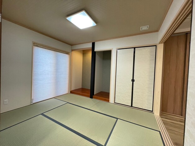 伝統的な畳が敷かれた和室の一角。収納力に優れた押入れと、自然光を取り入れる障子窓が特徴。シンプルで落ち着いた雰囲気が漂う空間。