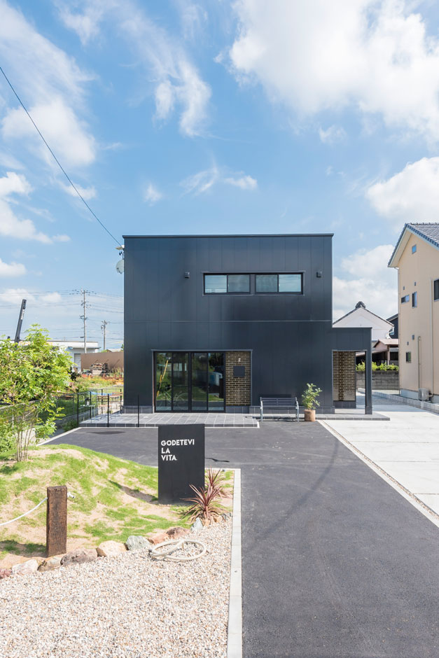 SEIEN ARCHITECT【趣味、建築家、インテリア】家の前にはイタリア語で「人生を楽しむ」と書かれたデザインが。人が集まれるように駐車スペースもたっぷり確保