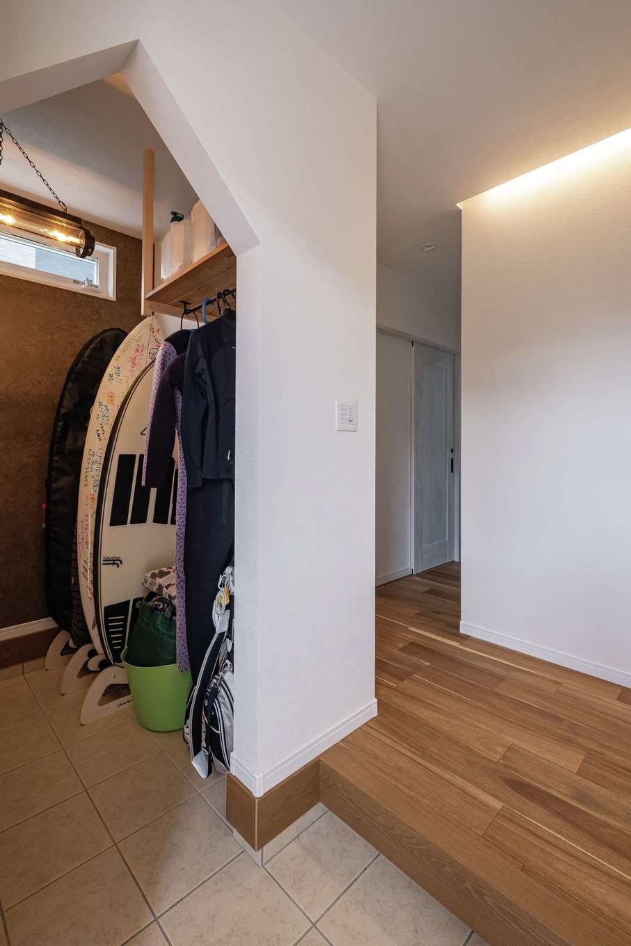 ぽっくハウス【リプルス】【デザイン住宅、趣味、間取り】サーフボードもウエットスーツもすっぽり収納できる大容量の玄関クローゼット。三角屋根の形をした垂れ壁がアクセントに