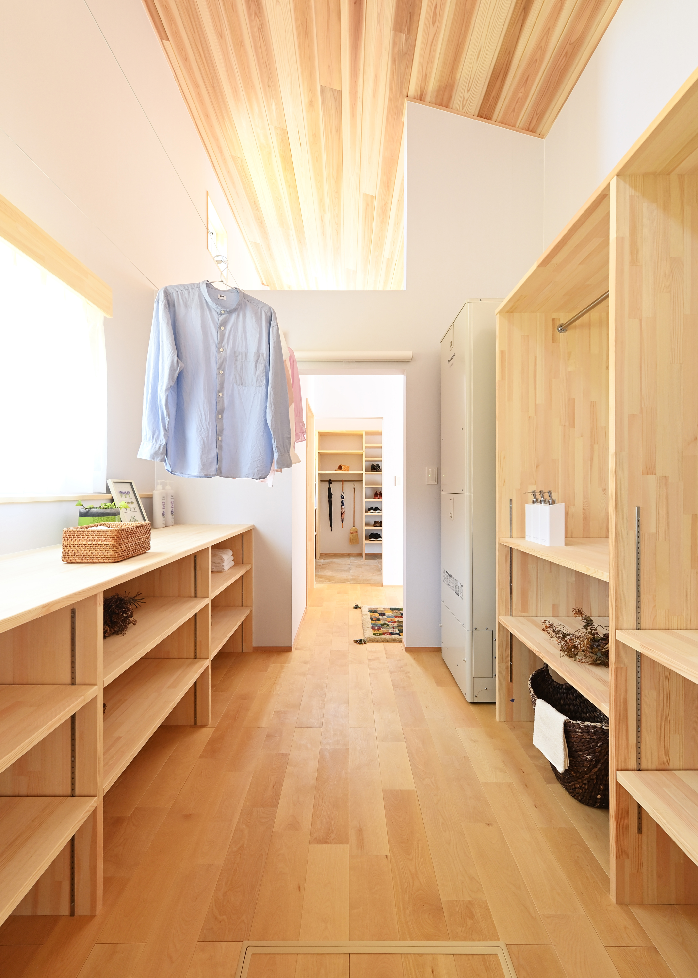 KANAZAWA STYLE/金澤建築【省エネ、間取り、平屋】土間収納→手洗い→トイレ→ランドリールーム→浴室へとつながる動線。高い断熱・気密・換気性能により、部屋干しの洗濯物がよく乾き、不快な臭いもしない。洗う・干す・アイロン・たたむ・収納が一か所で完結できる。収納棚の高さは、現場で施主さんを交えて二度確認してから決めた