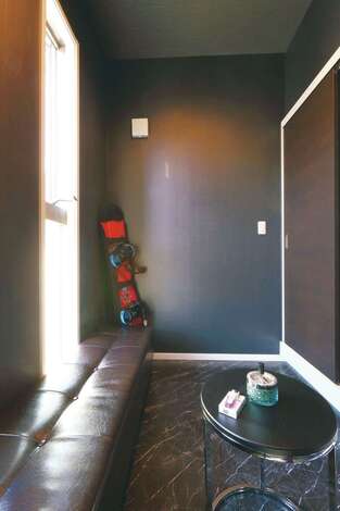 リビングと隣接するフリールームは、ご主人の趣味部屋。高級感のあるフロアタイルに革のベンチ、スリット窓、コーヒーテーブルがいい感じで調和している。喫煙専用ルームとして使うにはもったいないほどカッコイイ空間♪