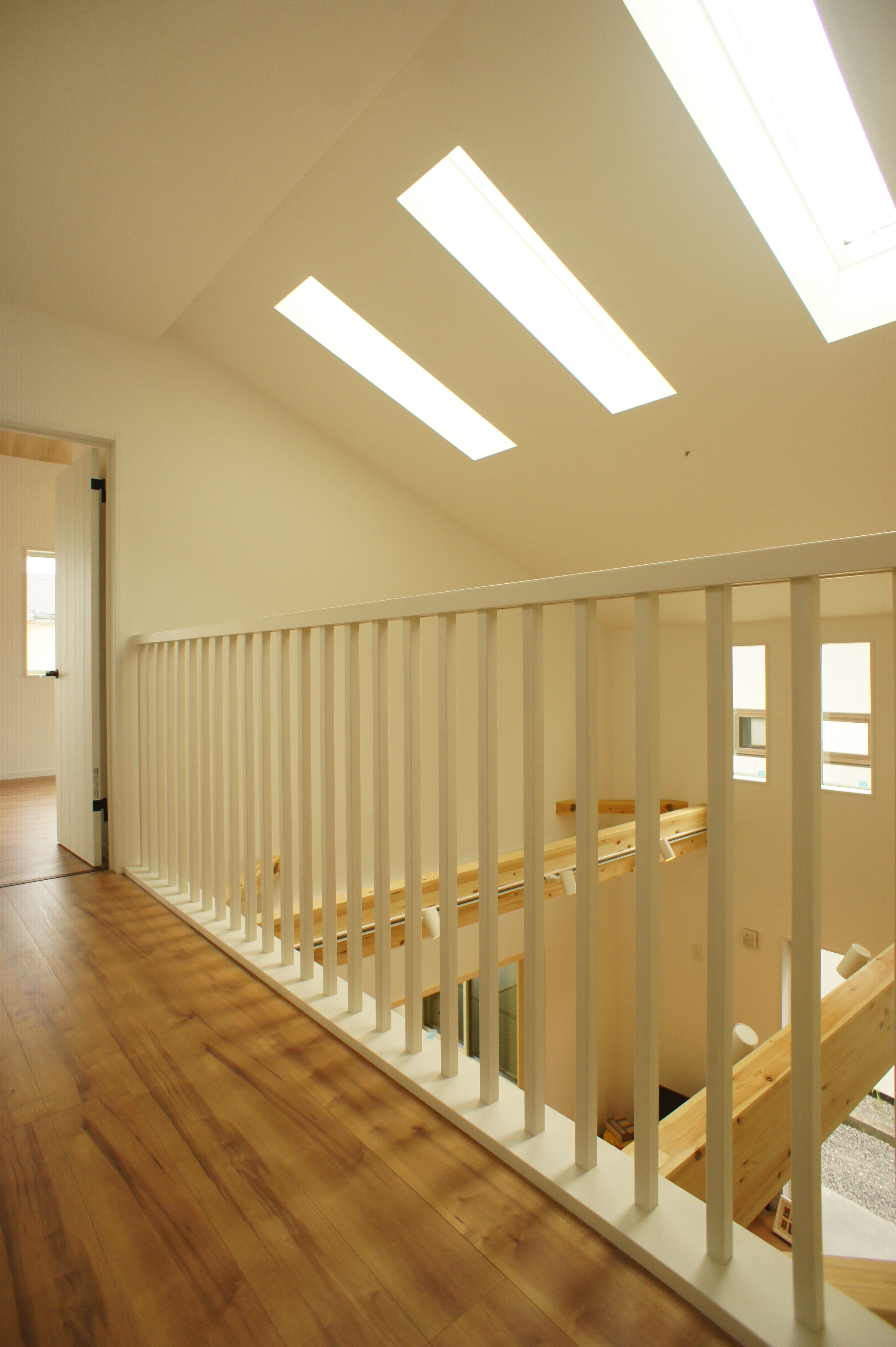 小野田産業～designers house project～｜上部に天窓が設けられた明るい廊下空間。木目調のフロアが優しい雰囲気を醸し出し、開放感を演出している。