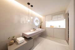 明るくモダンな洗面スペース。間接照明が心地よい空間を演出し、使い勝手の良い広々としたカウンターが備えられている。