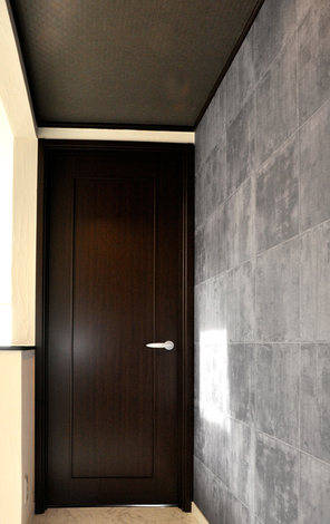 階段を上がると、そこはリビングのナチュラルモダンとは雰囲気の異なる大理石調の床やダークな色づかいのドアなど、大人の空間になった