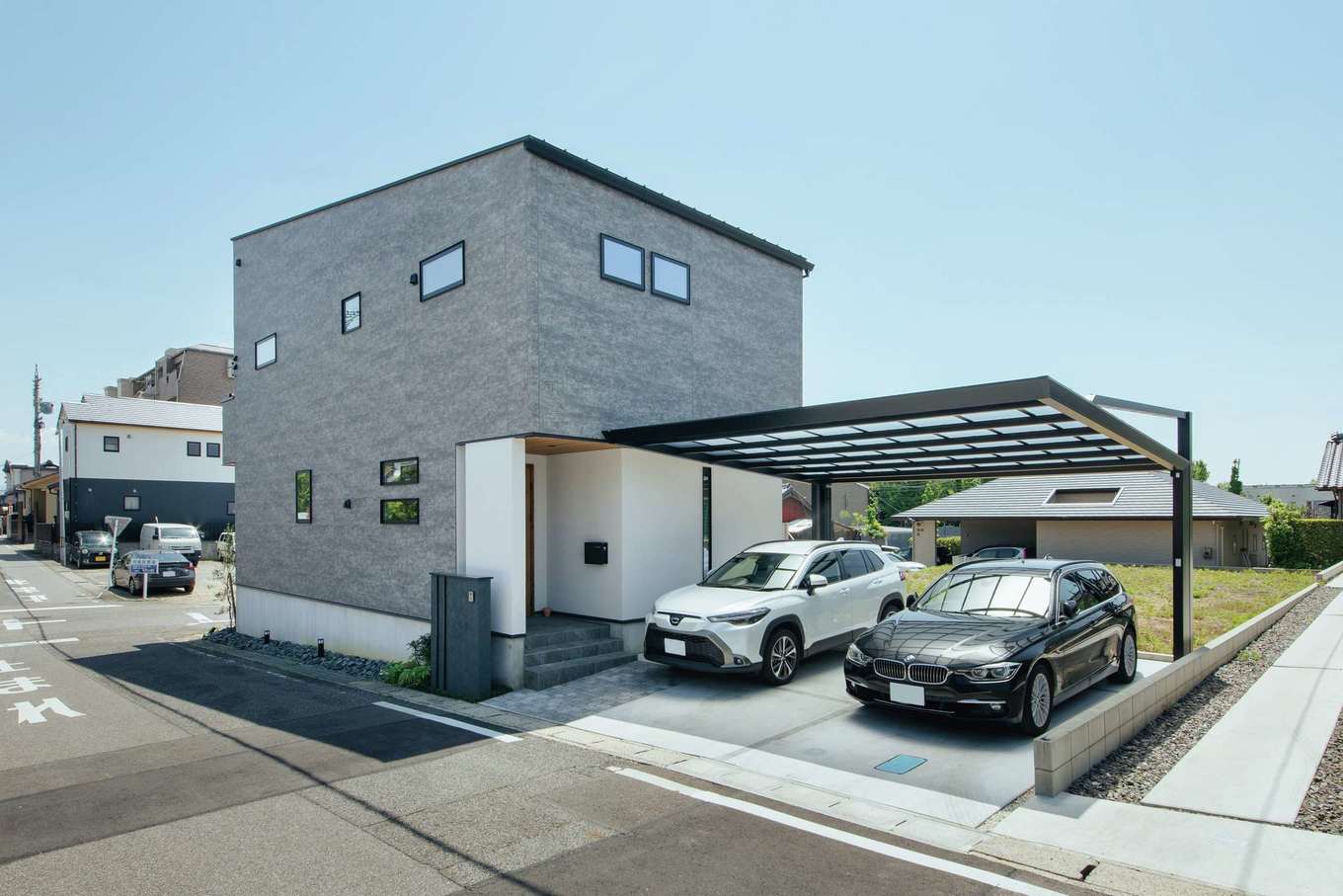 SEVEN HOUSE/セブンハウス【デザイン住宅、子育て、間取り】グレーと白、軒天のレッドシダーが調和したシックな外観。2階にロフトをつくるため、斜線規制に触れないギリギリのラインに建物を配置した