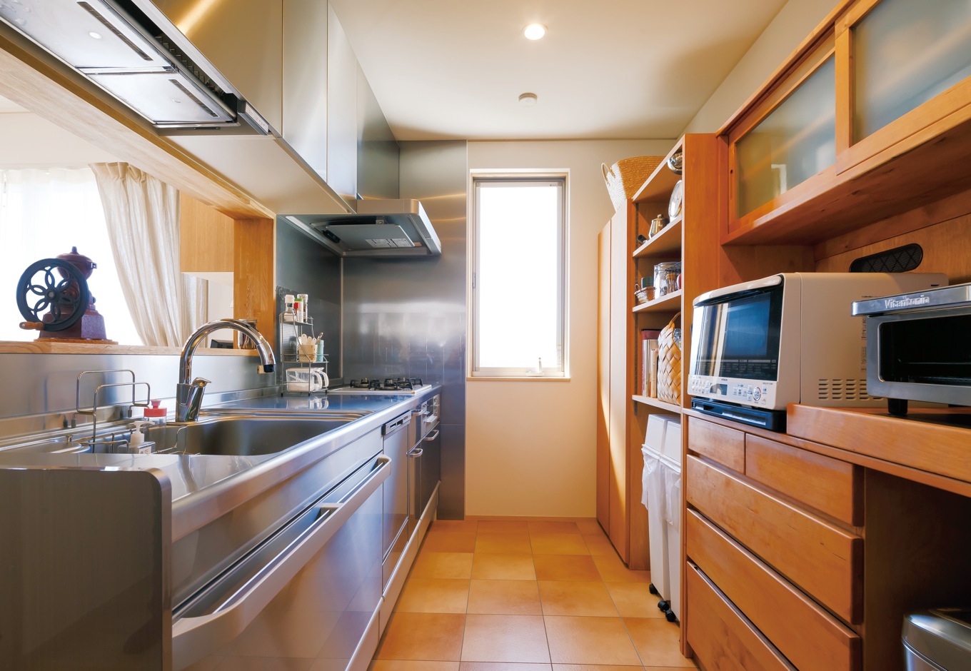 神谷綜合建設 カミヤの家【自然素材、間取り、インテリア】写真手前の手持ちの家具に合わせて、その横に家具職人が色目も材質もそっくりな棚を造作。全体がフルオーダーの家具のようにキッチンの背面にぴったりと収まっている