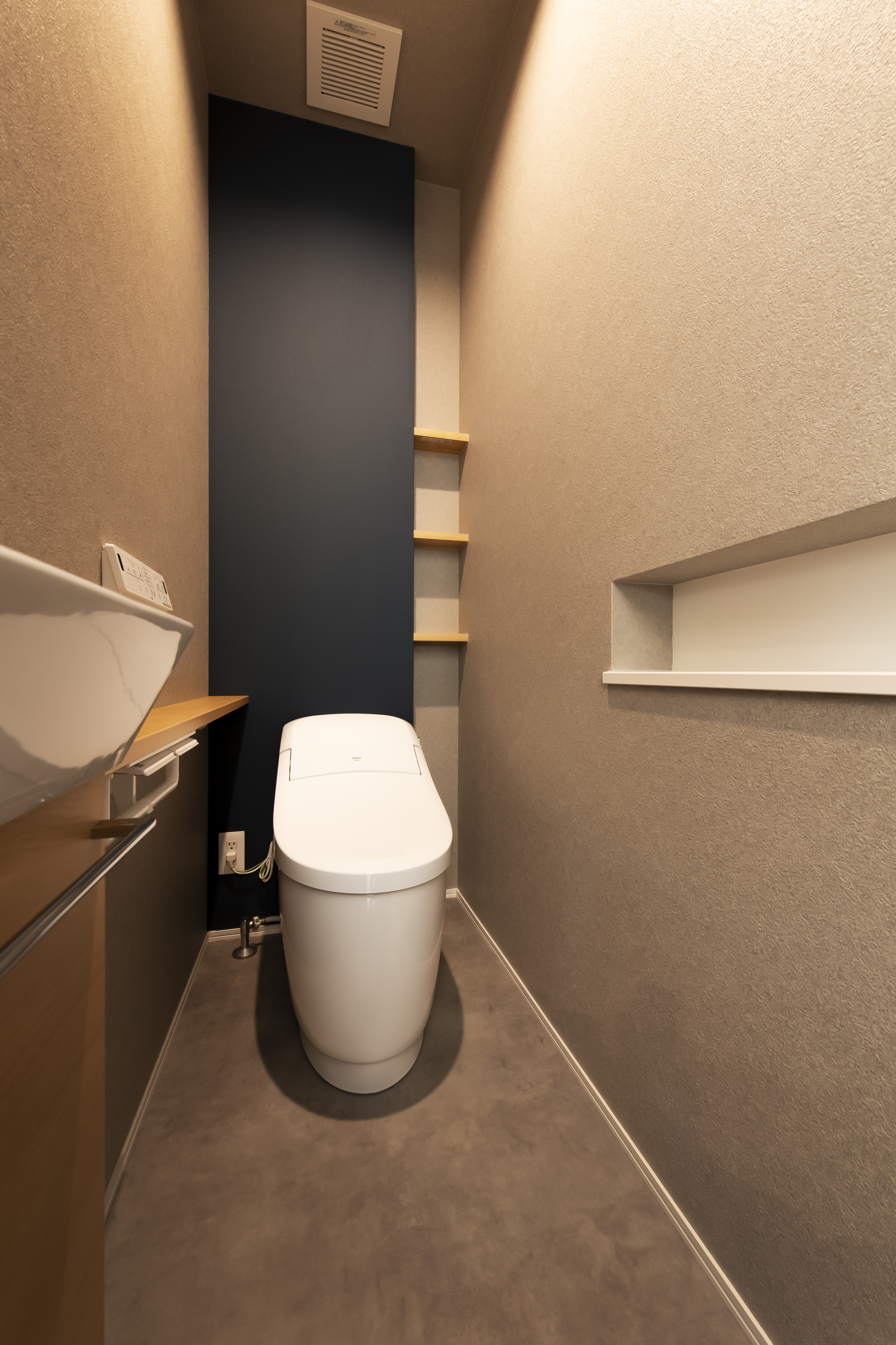 スズイチ｜コンパクトかつシックなデザインのトイレ。緻密なスペース割りが施され、機能的で快適なトイレ空間である。