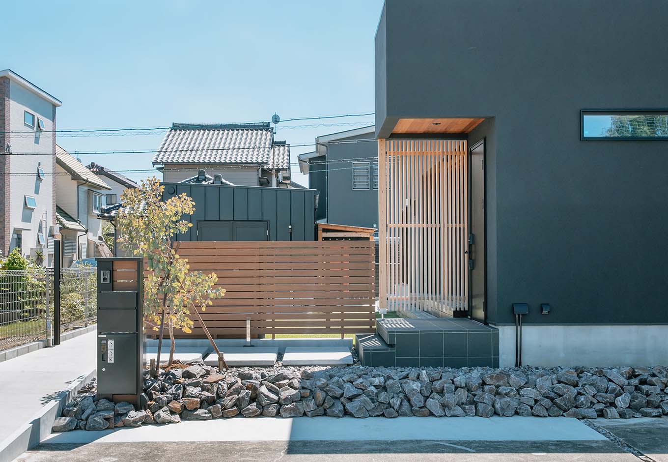 平屋建築ブルーハウス【デザイン住宅、建築家、平屋】外から家の中が見えないよう設置した杉格子の目隠しが外観にアクセントをつける。ワンポイントに木を使用することで、重たい印象にならない