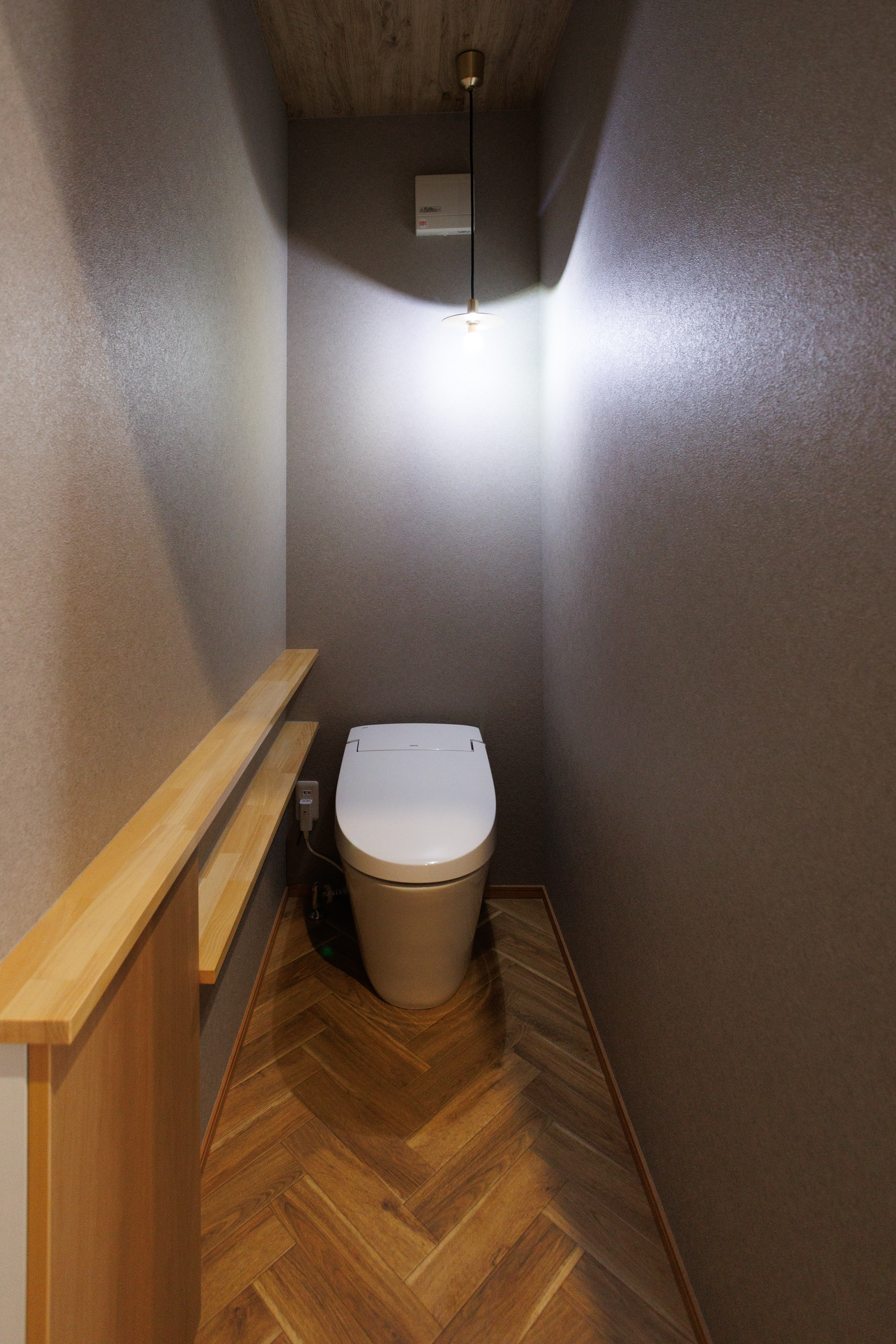 タムラホーム｜落ち着いた色調のトイレ空間。シンプルな照明がアクセントになっており、優雅でありながら機能的なデザイン。