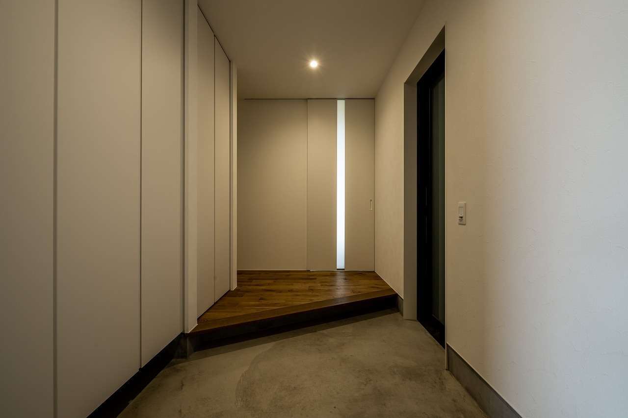 アーキテックス【デザイン住宅、省エネ、平屋】インナーガレージから濡れずにアクセスできる玄関ホール。壁一面に大容量のシューズクローゼットを設けて、空間を常にすっきりと保つ