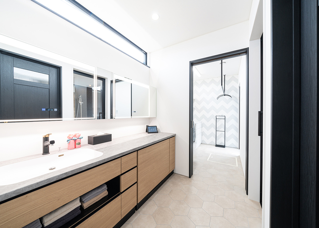 オリジナル造作の洗面化粧台。鏡を3枚設置して、朝の混雑を解消した。専用チェアが組み込まれている