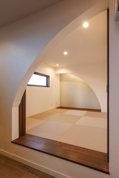 2連のアールが美しい小上がりの和室。あえてベッドルームを設けず、夜は布団を敷いて寝室として使う